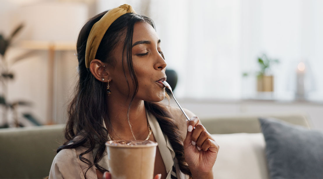 Attractive female eating the healthiest ice creams in the comfort of her own home