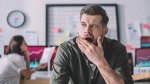 Young male office worker suffering from afternoon brain fog