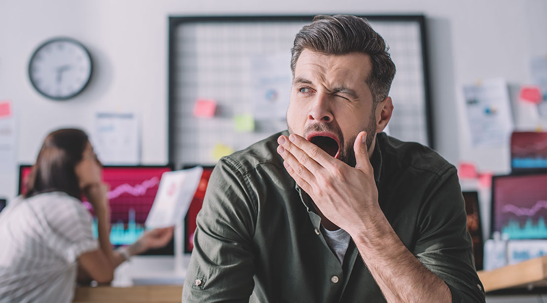 Young male office worker suffering from afternoon brain fog